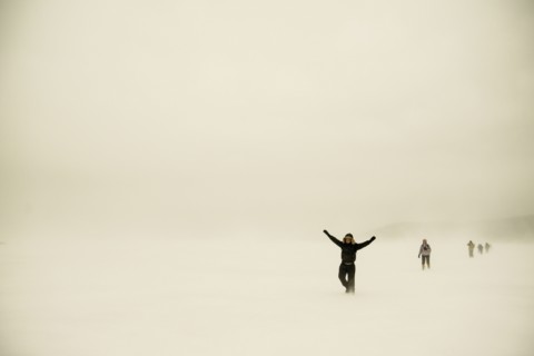 Caucasian hikers walking in snowy remote field