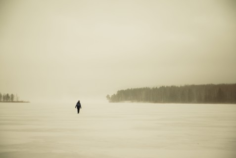 Caucasian hiker walking in snowy remote field