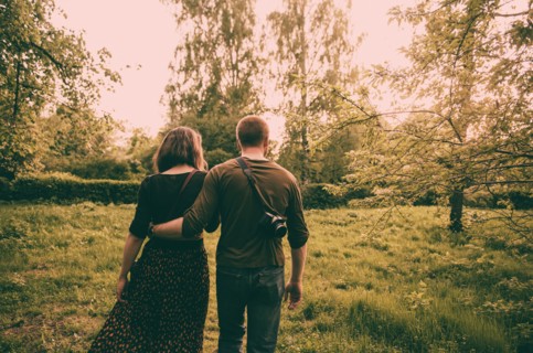 Caucasian couple walking in field