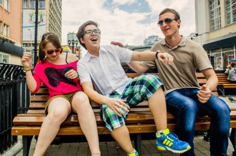 Caucasian friends playing on city bench