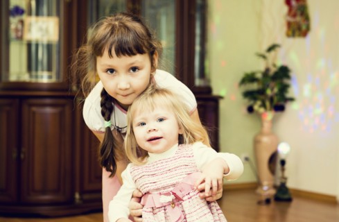 Caucasian sisters playing in house