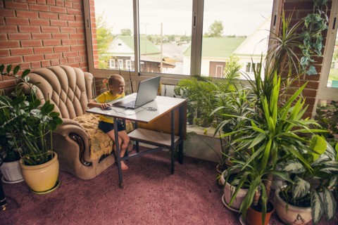 Caucasian boy using laptop at desk