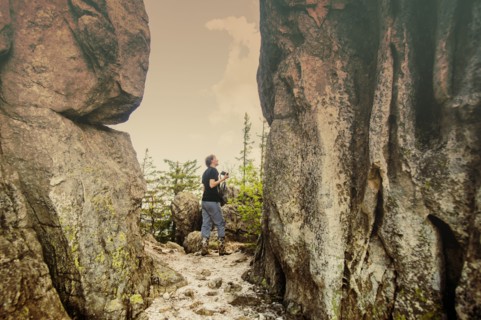 Caucasian hiker walking by remote cliffs