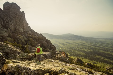 Caucasian hiker walking on rocky hillside in remote landscape