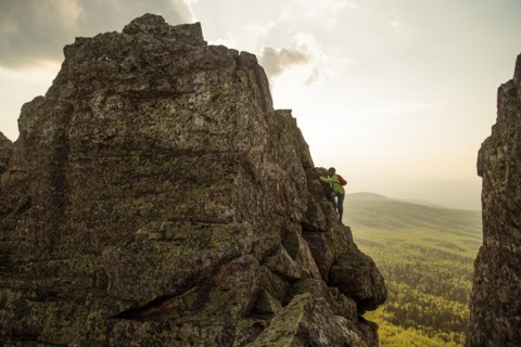 Caucasian hiker climbing on rock formation