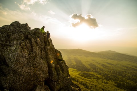 Caucasian hikers on rocky hilltop in remote landscape