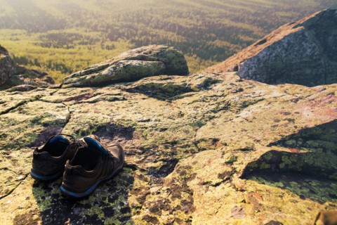 Close up of sneakers on rocky hilltop in remote landscape