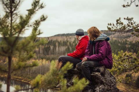 Friends sitting on rock on remote hillside