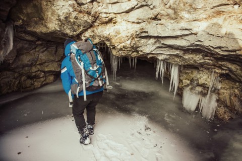 Caucasian woman exploring stalactites in cave