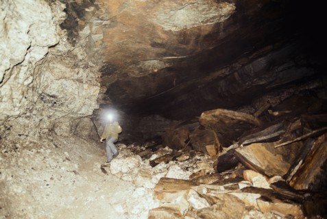Caucasian hiker wearing headlamp in cave