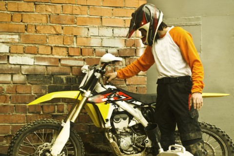 Caucasian man examining dirt bike