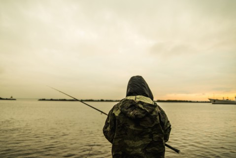 Caucasian man fishing in remote lake