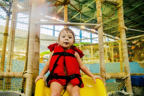 Caucasian girl riding slide at water park