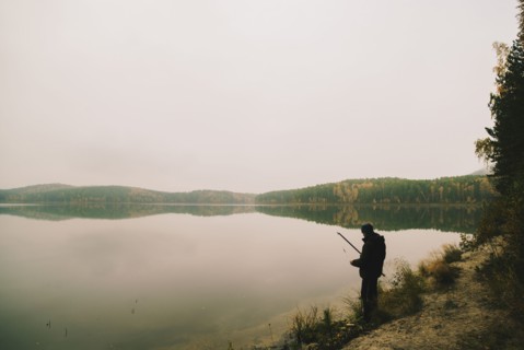 Man fishing in remote lake