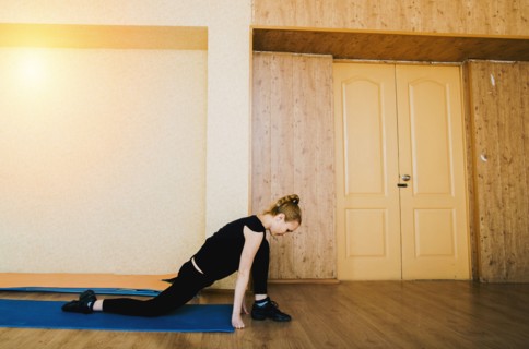 Caucasian dancer stretching in studio
