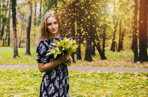 Caucasian woman carrying bouquet in park
