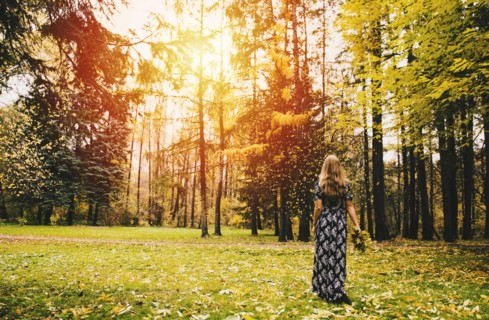 Caucasian woman carrying bouquet in park