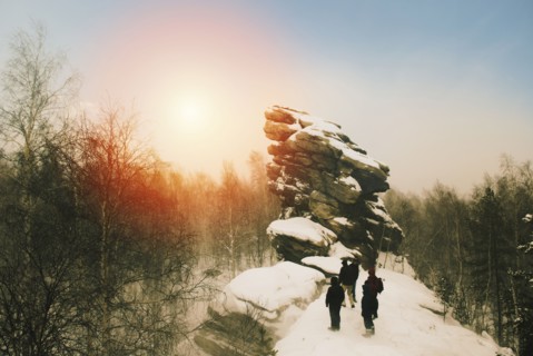 Caucasian hikers on snowy remote hilltop