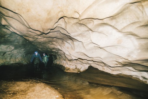 Caucasian hikers exploring cave