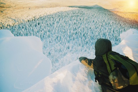 Hiker admiring view from snowy hilltop