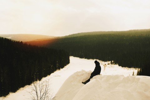 Caucasian hiker sitting on snowy mountain