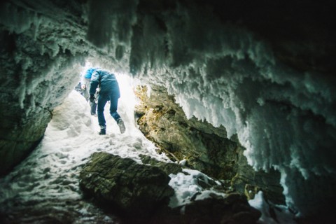 Caucasian hiker walking in icy cave