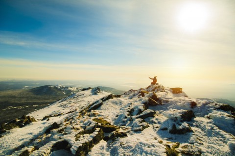 Woman sitting on mountain in winter