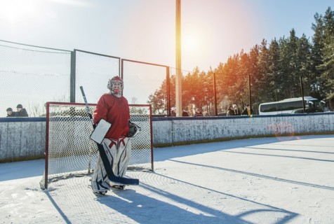 Caucasian boy playing goalie in ice hockey outdoors