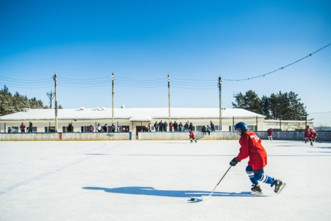 Caucasian boys playing ice hockey outdoors
