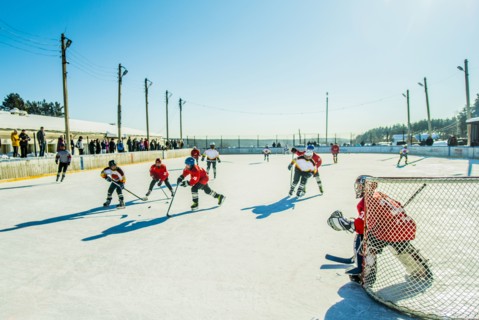 Caucasian boys playing ice hockey outdoors