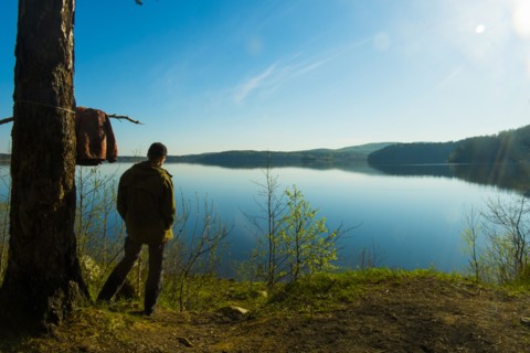 Caucasian man standing at lake admiring scenic view