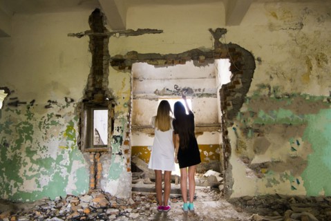 Women standing in doorway of dilapidated building