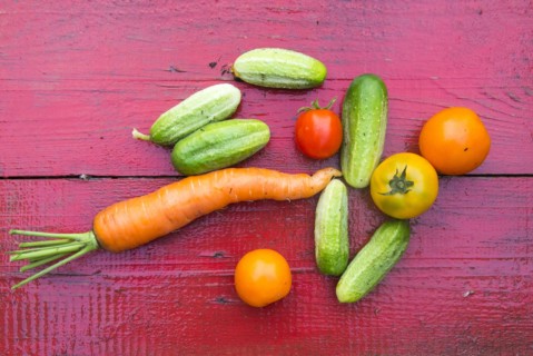 Close up of fresh vegetables on red wooden table