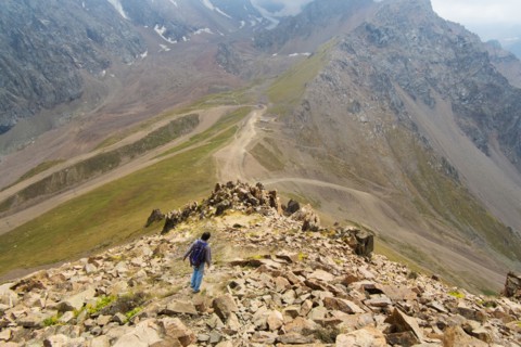 Caucasian man hiking on mountain rocks