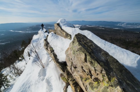 Caucasian man hiking on mountain in winter
