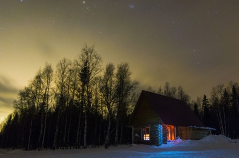 Light glowing in remote cabin in winter