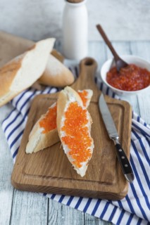 Bread with caviar on cutting board