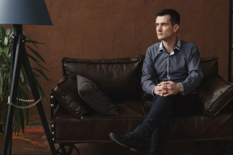 Pensive Middle Eastern man sitting on sofa