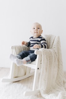 Curious Caucasian baby boy sitting in chair