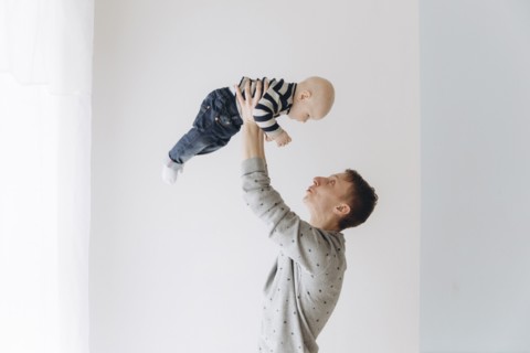 Caucasian father lifting baby son