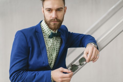Stylish Middle Eastern man with beard holding sunglasses