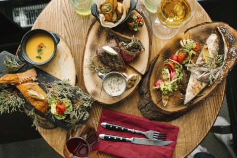 Variety of meat and fish on table with wine