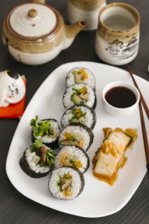 Sushi on plate with sauce and chopsticks