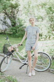 Middle Eastern woman holding bouquet and standing with bicycle