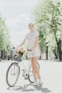 Portrait of Middle Eastern woman holding bouquet and bicycle