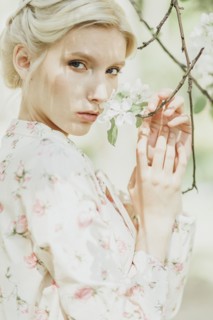 Middle Eastern woman smelling flowers on tree