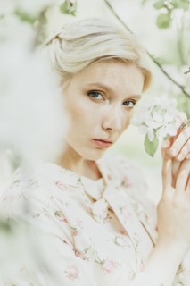 Middle Eastern woman holding flowers on tree