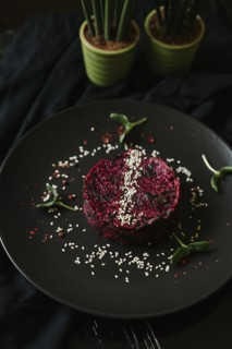 Sesame seeds and garnish on red food on plate