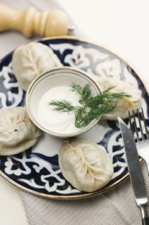 Dumplings and sauce on plate with fork and knife