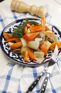 Meat and vegetables on plate with fork and knife